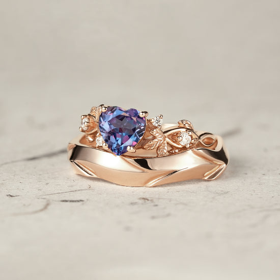 Heart-shaped alexandrite ring set with rose gold leaves and moissanite accents.