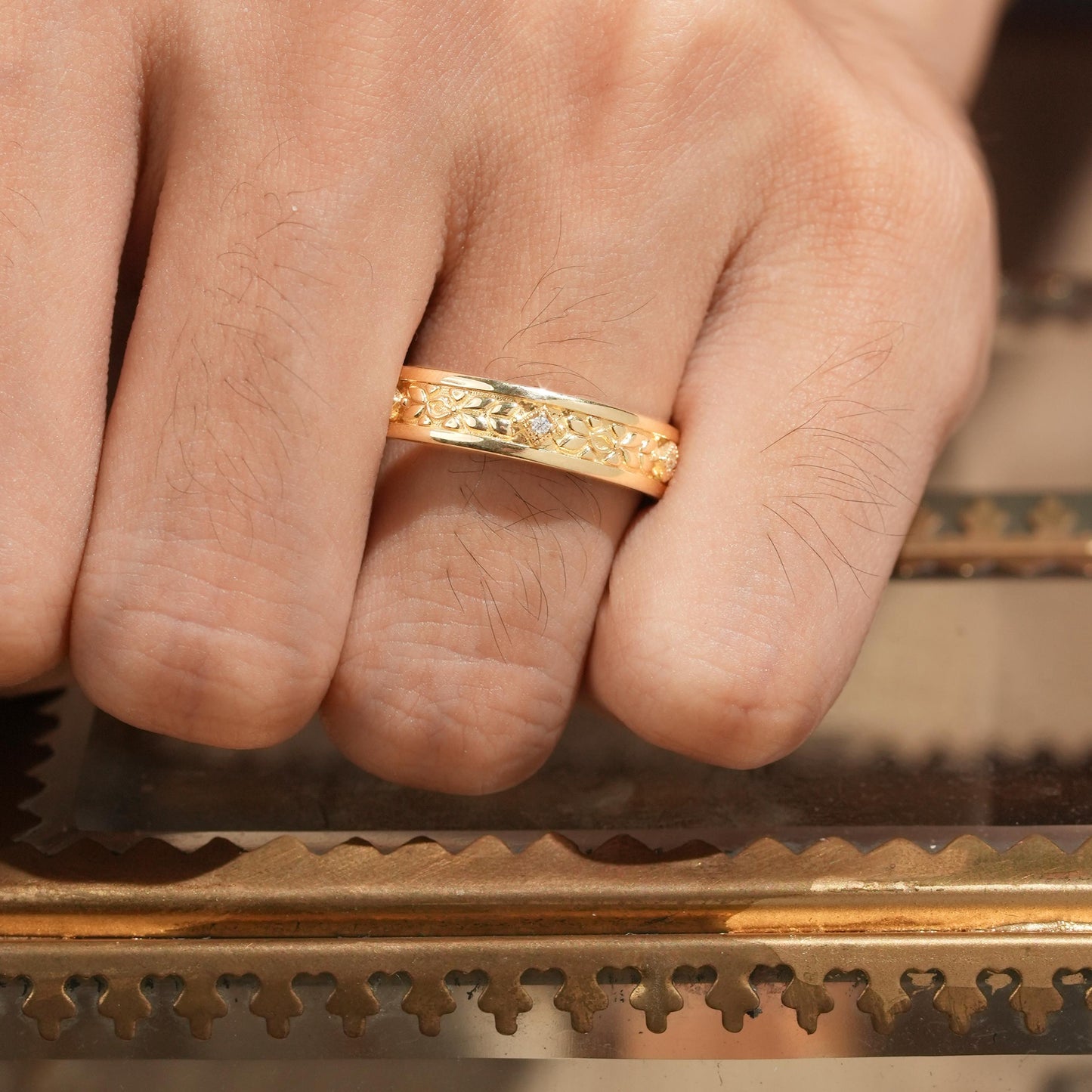 Vintage yellow gold men's ring with intricate leaf and vine engravings.