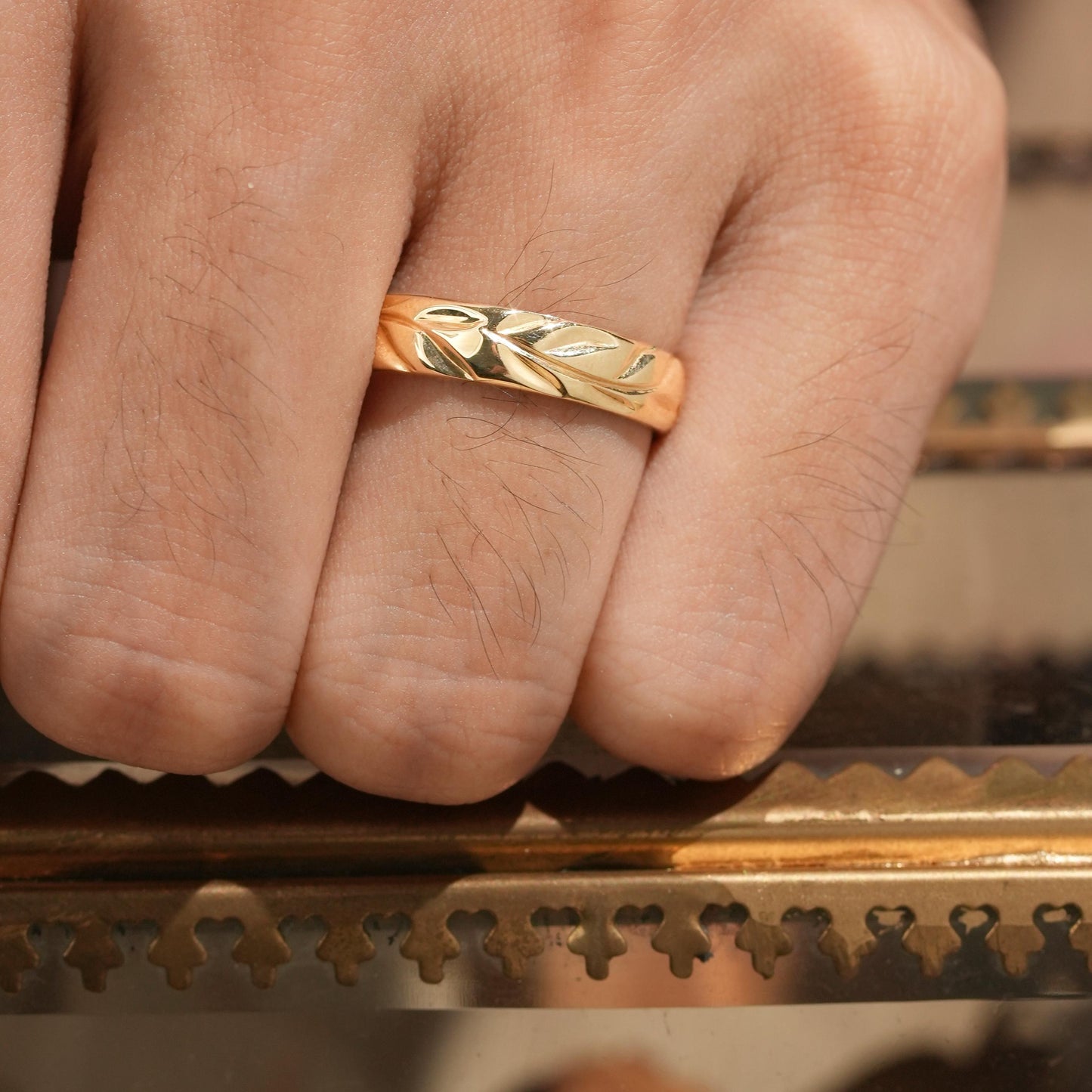 Men's polished leaf band ring in yellow gold showcasing an elegant nature-inspired design.