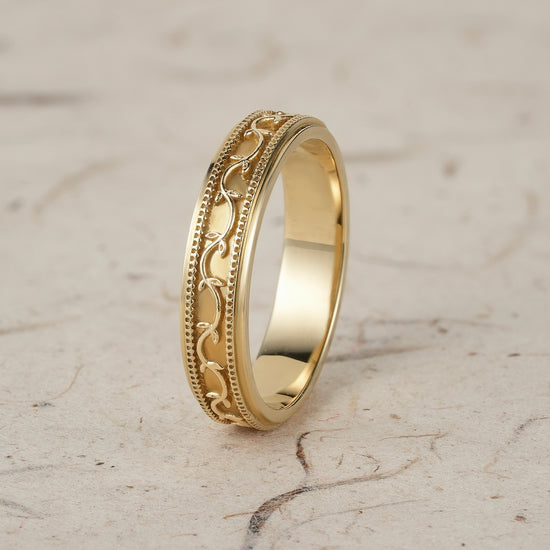 Polished yellow gold men's band featuring vine texture and milgrain detailing