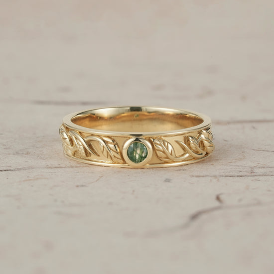 Men's moss agate leaf band ring in yellow gold with nature-inspired design.