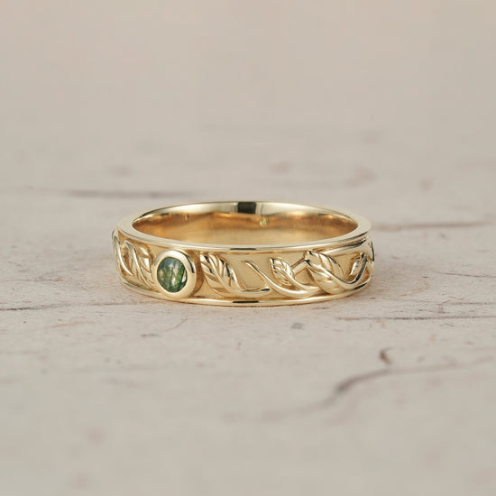 Men's yellow gold ring featuring moss agate and intricate leaf design.