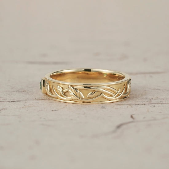 Nature-inspired moss agate leaf band ring in yellow gold with intricate design.