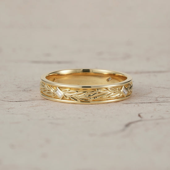 Elegant yellow gold men's band with intricate leaf detailing and moissanite accents.