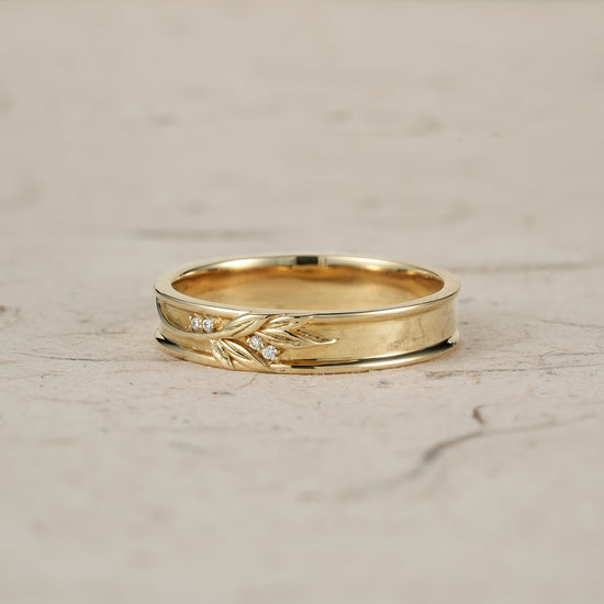 Gold men's ring with elegant leaf engravings and diamond accents.