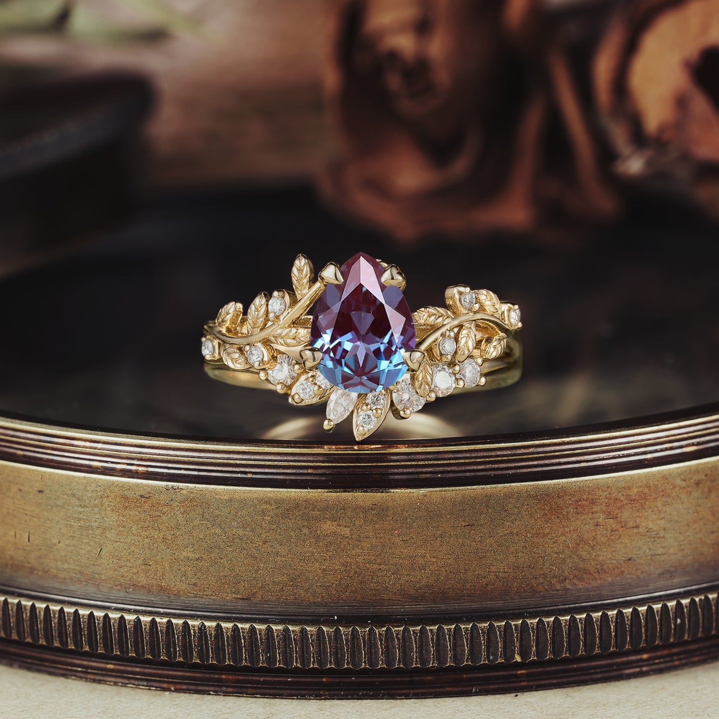 Alexandrite engagement ring set in gold with leaf design and moissanite accents