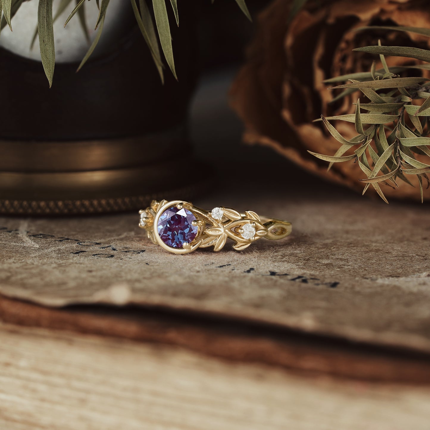 Elegant gold ring with round alexandrite and floral patterns, accented by moissanite stones.