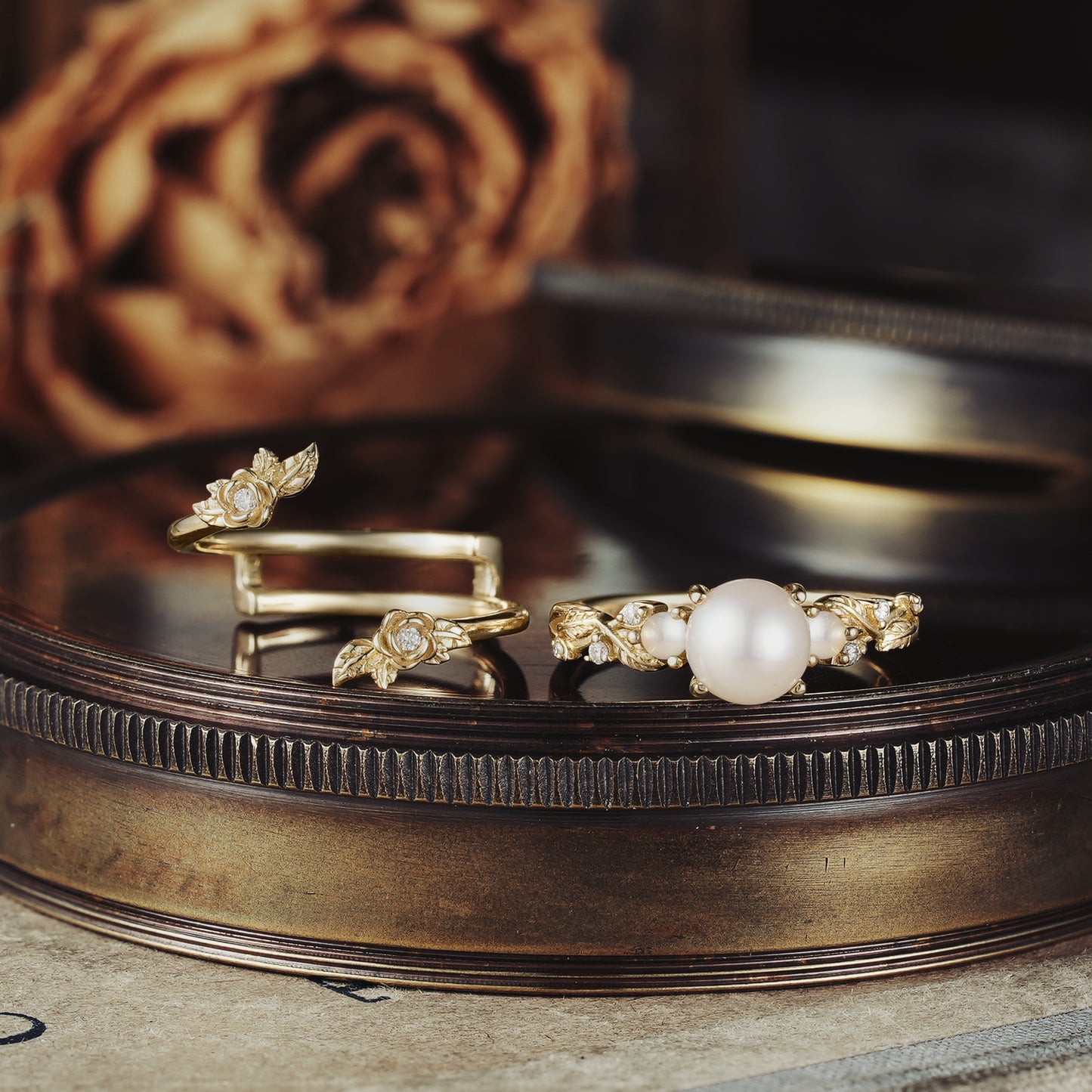 Rose Blossom pearl ring set with floral motifs on a vintage mirror