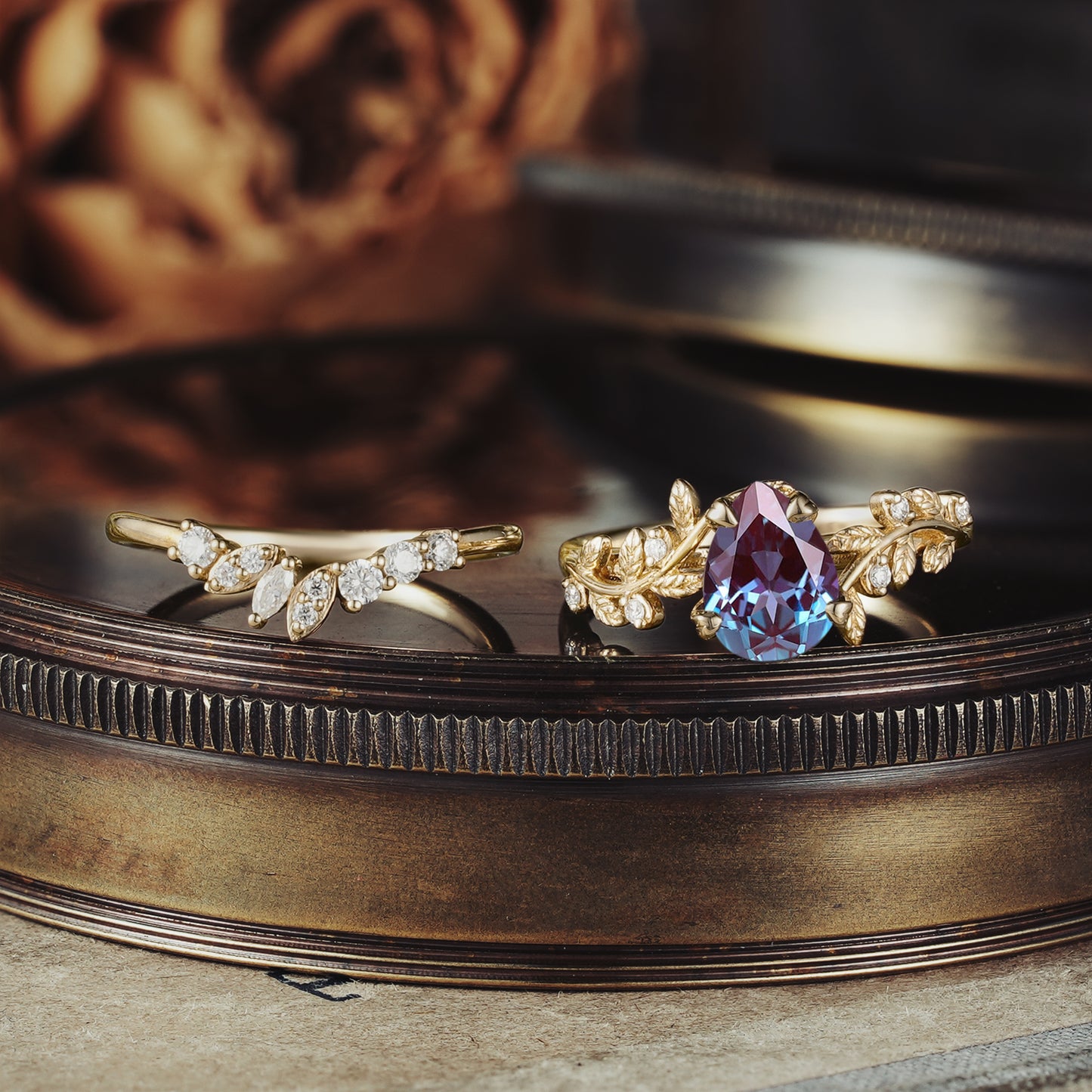 Alexandrite ring set with leaf motifs in gold and moissanite accent stones.