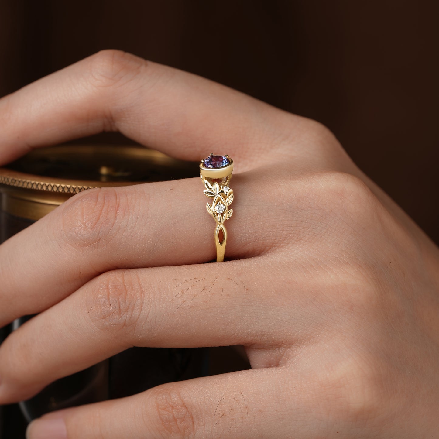 Celestial Blossom gold ring with round alexandrite and floral accents on a hand