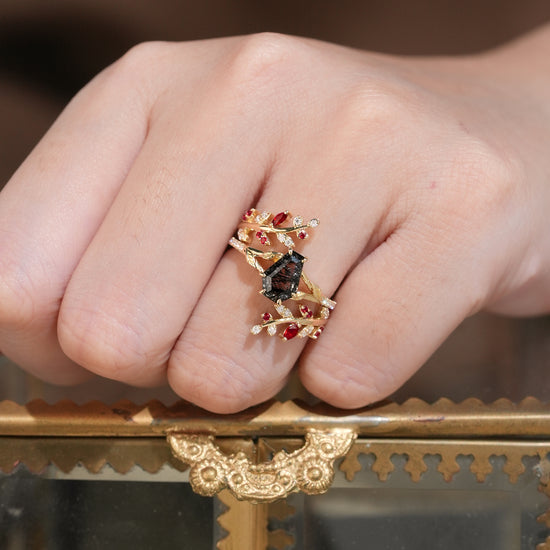 Nature-inspired black rutilated quartz ring set with rubies on a hand