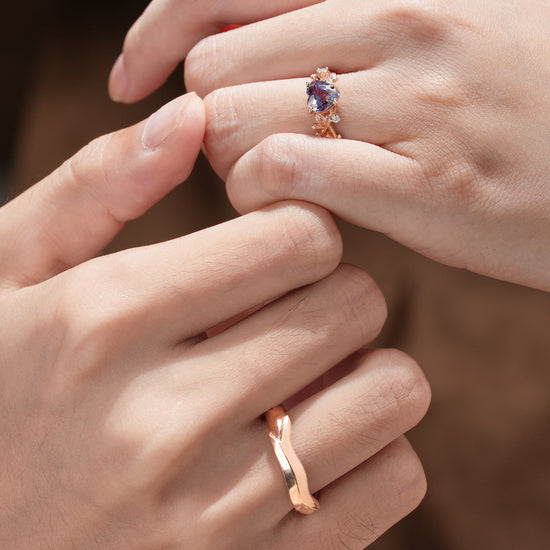 Couple showing heart alexandrite ring and rose gold band on their hands.