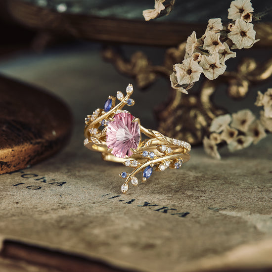 Padparadscha engagement ring with gold vine design and sparkling accent stones.