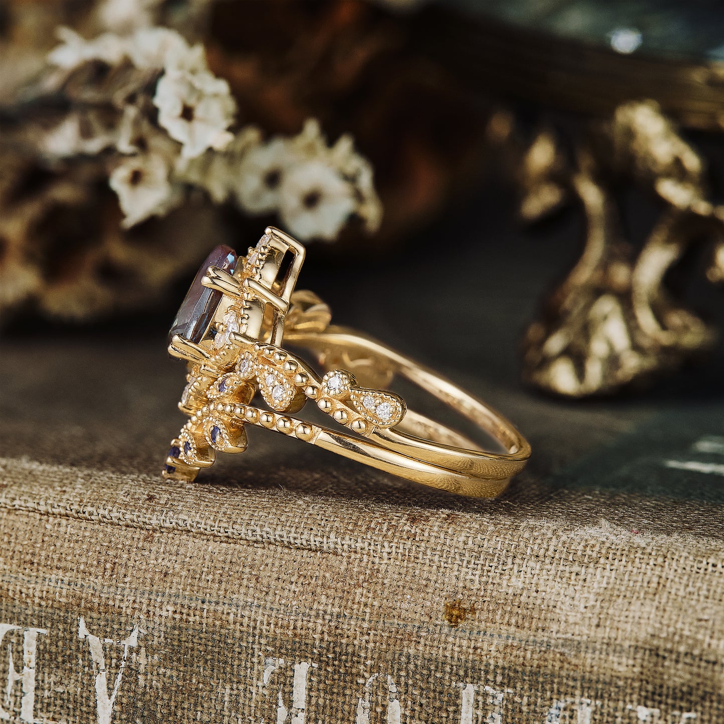 Nature-inspired twisted gold engagement ring with pear-cut alexandrite and moissanite.