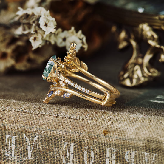 Moss agate and sapphire engagement ring in gold with intricate vine design and detailed accents