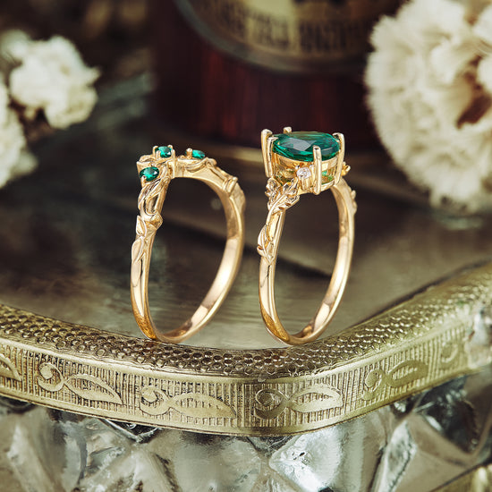 Leaf-inspired gold rings with lab emerald centerpiece and green stone accents