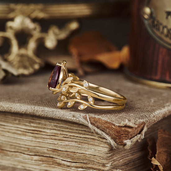 Unique pear cut alexandrite ring set with leaf accents in yellow gold.