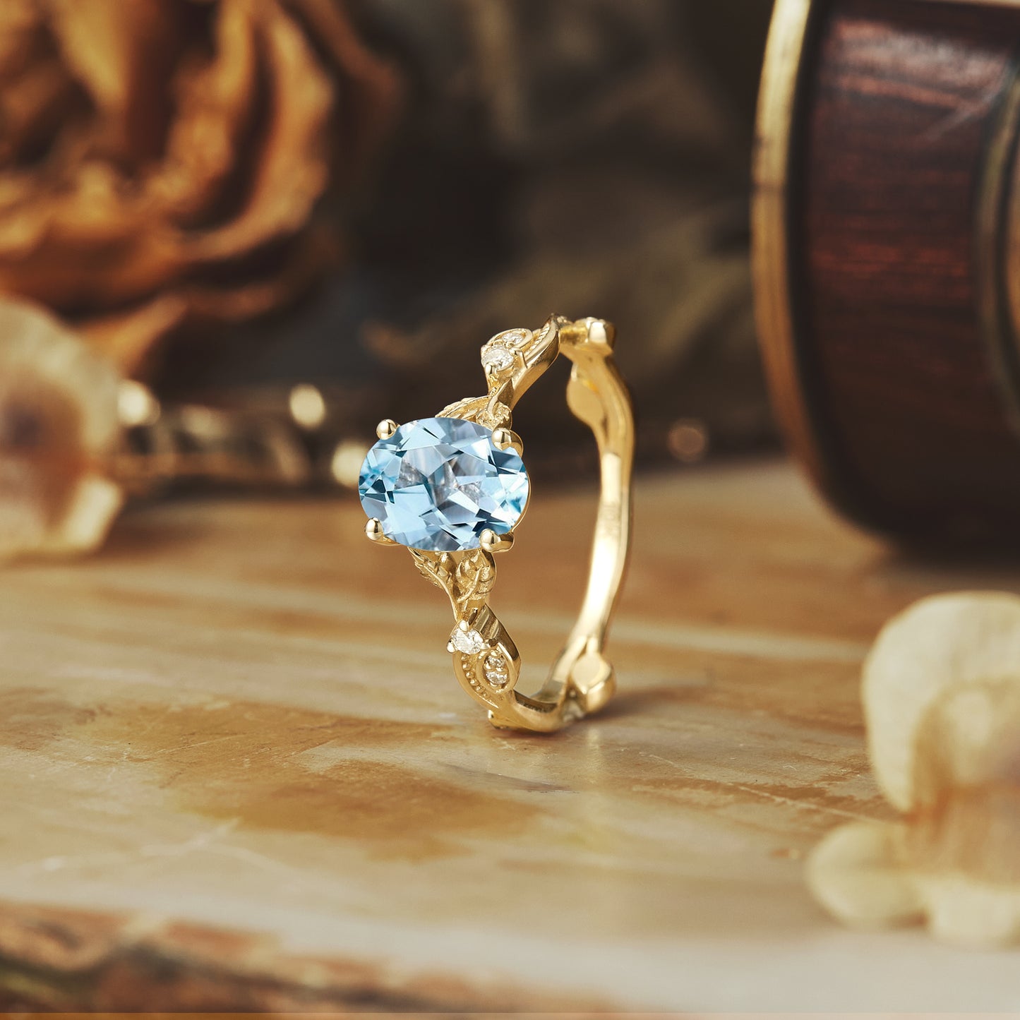 Vintage aquamarine engagement ring with floral band on wooden surface.