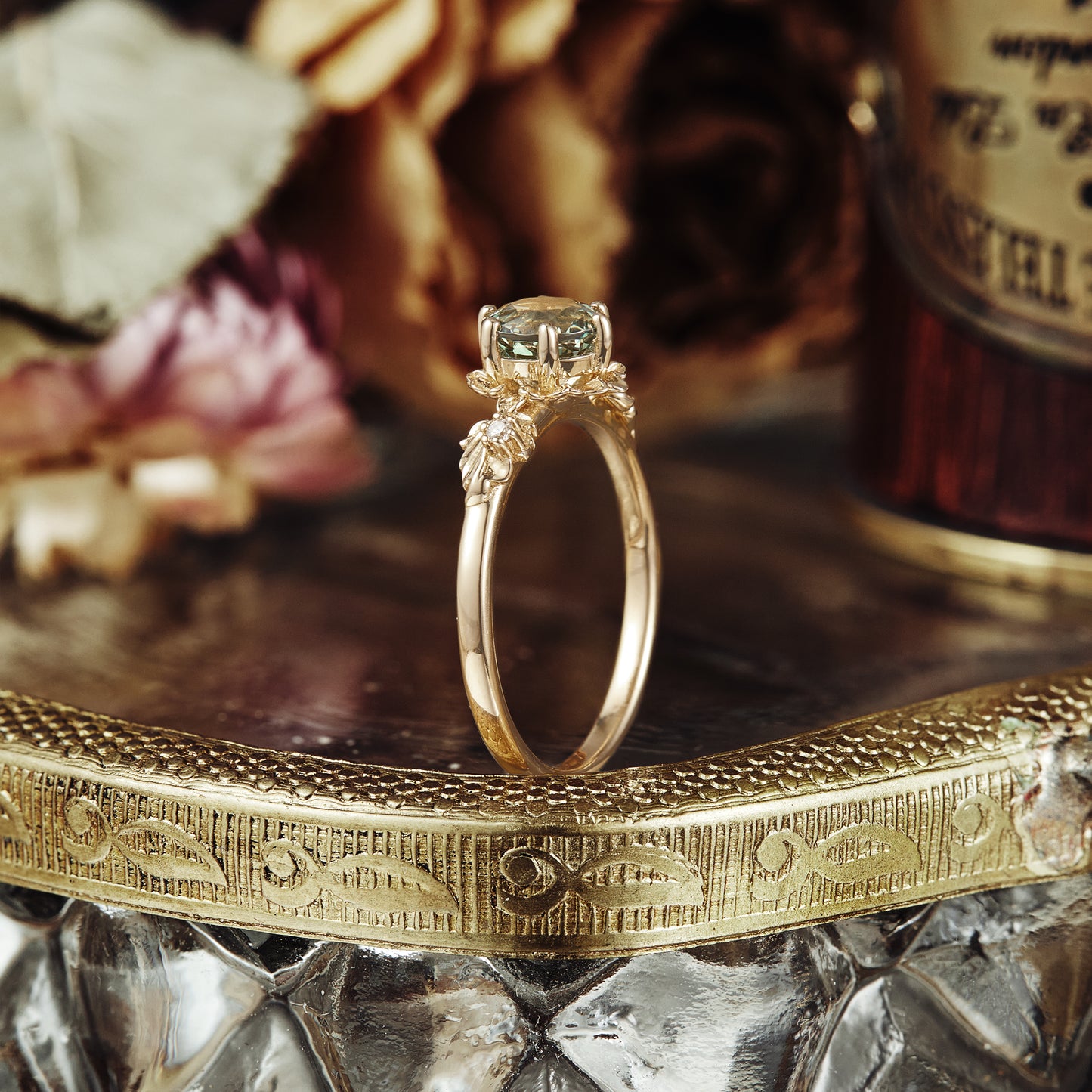 Beekeeper Garden Ring with round green sapphire and leaf details on an engraved vintage tray.