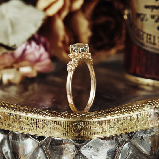 Beekeeper Garden Ring with round green sapphire and leaf details on an engraved vintage tray.