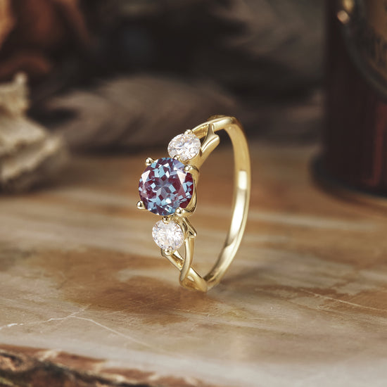 Elegant three-stone ring with round Alexandrite and Moissanite in twisted yellow gold setting