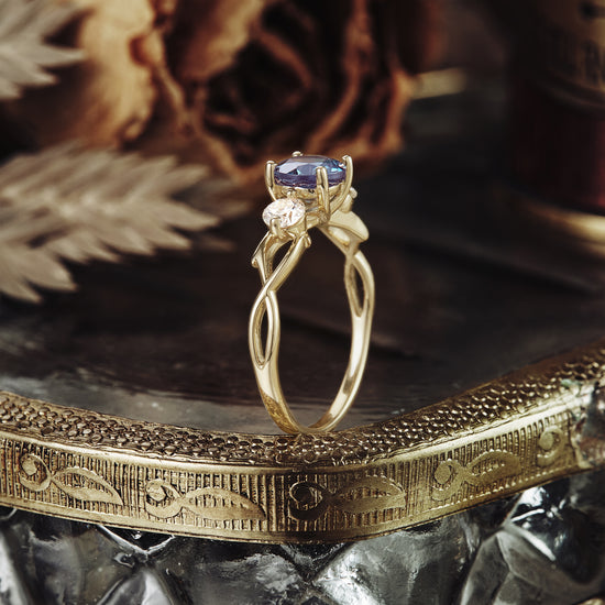 Three-stone twisted gold ring featuring round Alexandrite and Moissanite gemstones