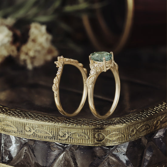 Gold ring set with pear-shaped green sapphire and leafy accents.