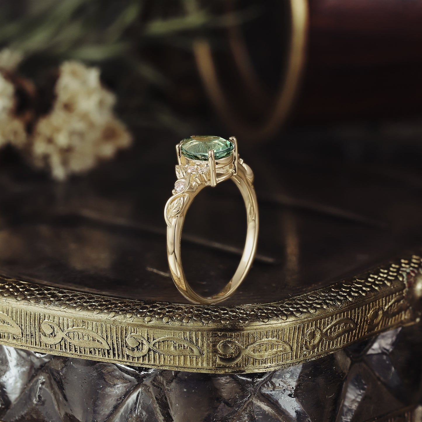 Gold ring with pear-shaped green sapphire and delicate leaf design