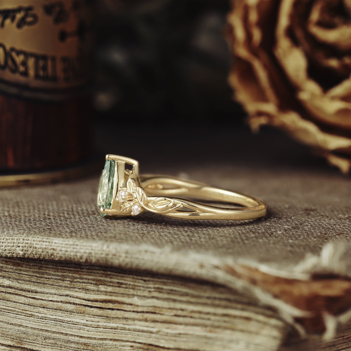 Leaf-design gold ring with pear-shaped green sapphire and diamond embellishments