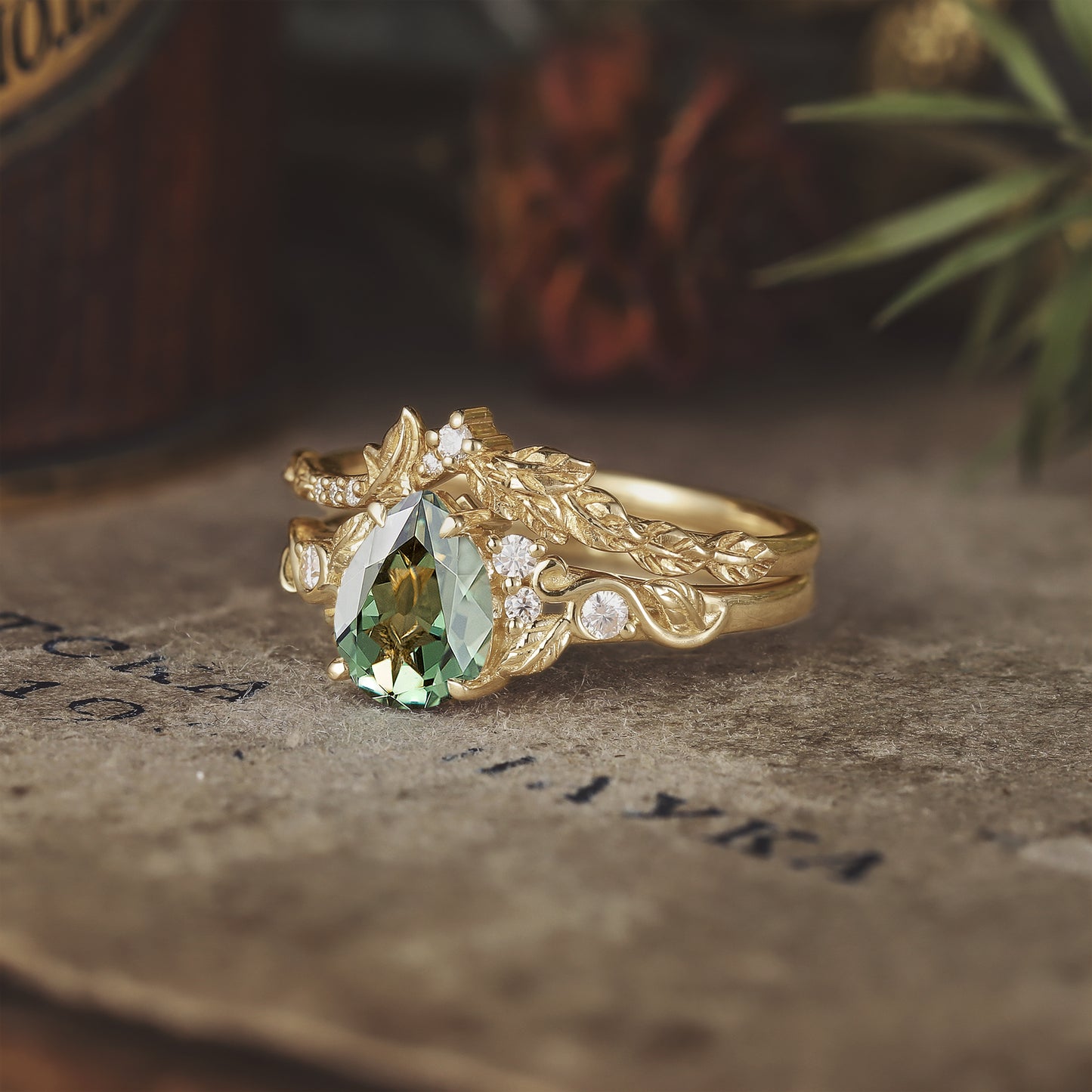 Leaf design gold ring set with pear-shaped green sapphire and moissanite accents