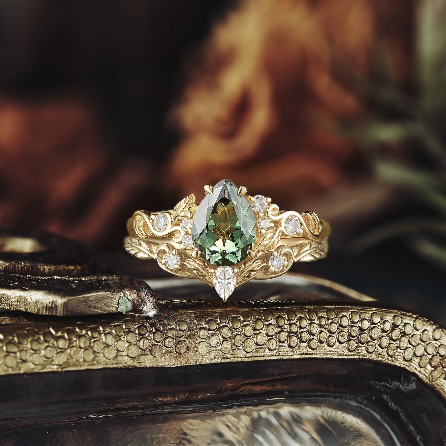 Leaf-inspired gold ring with pear-shaped green sapphire and moissanite accents