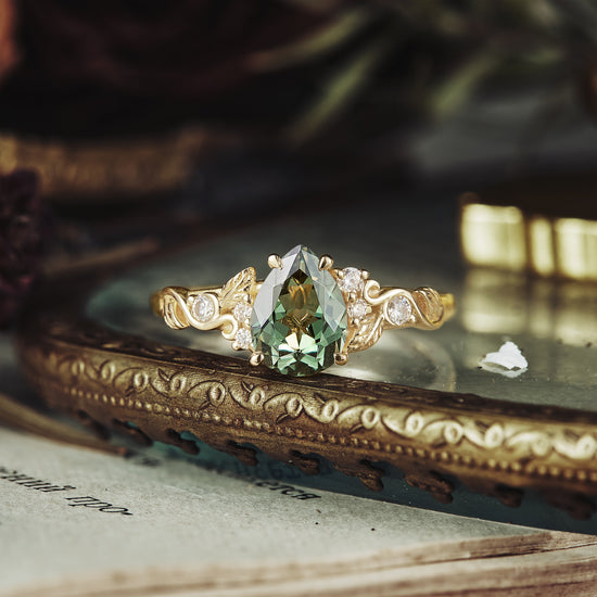 Nature-inspired gold ring with pear-shaped green sapphire and diamond accents