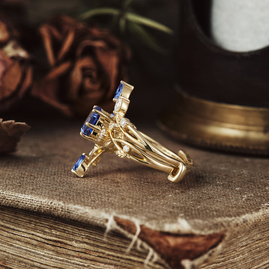 Claire hexagon sapphire vine ring set with moissanite accents in gold on rustic surface