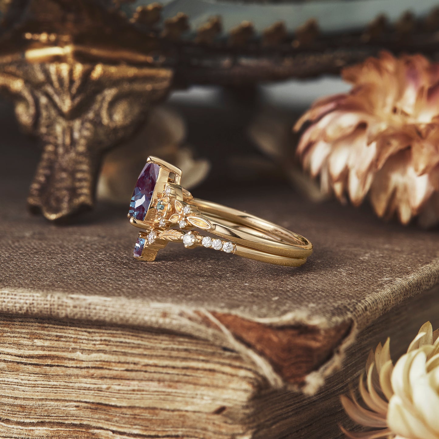 Elegant gold ring showcasing pear-shaped alexandrite with floral design and accent diamonds