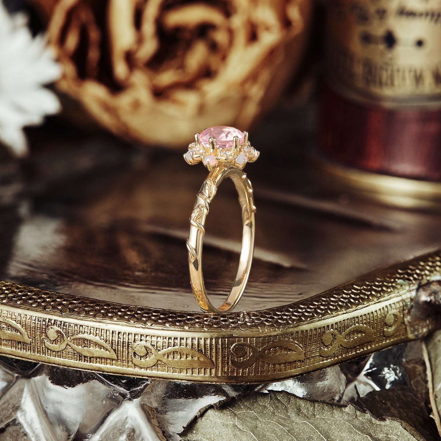 Halo pink Padparadscha engagement ring with floral design on vintage tray.