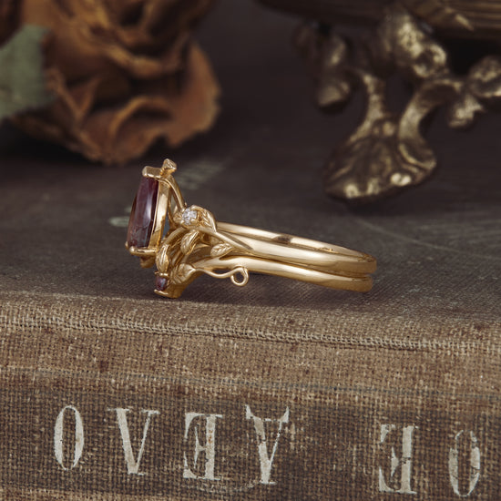 Nature-inspired gold ring set with pear lab alexandrite and moissanite accents.