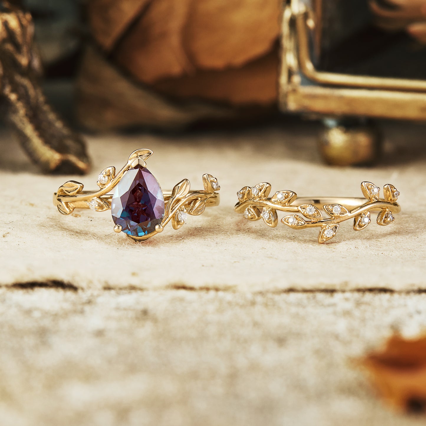 Nature-inspired pear cut alexandrite ring set with floral accents in gold.