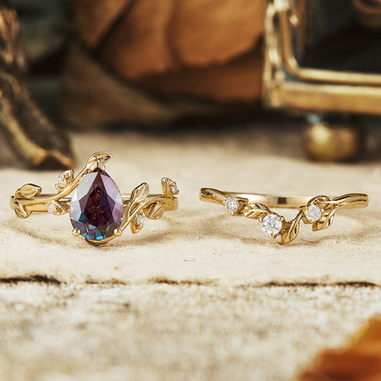 Gold pear-shaped alexandrite engagement ring set with floral leaf accents