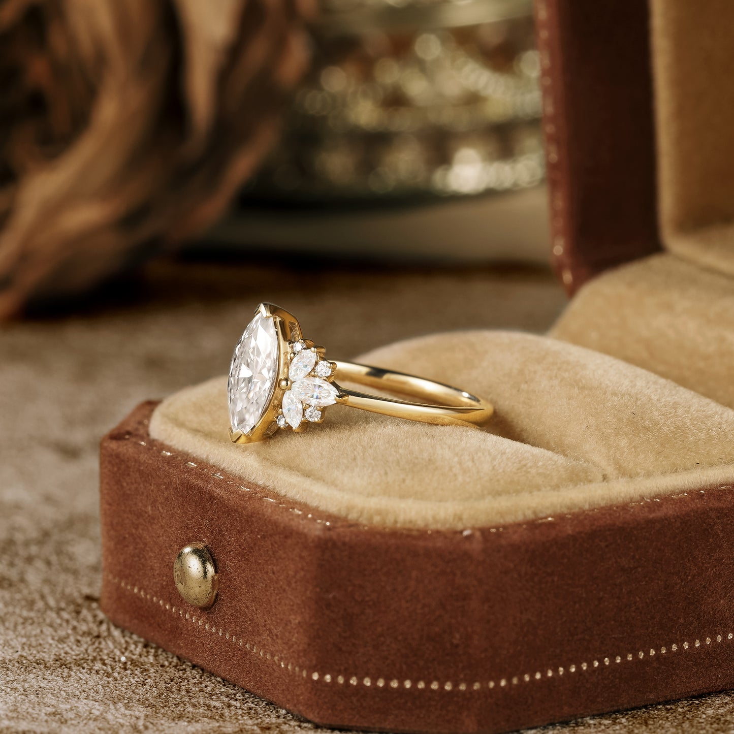 Marquise cut moissanite ring with floral side stones in brown velvet box.