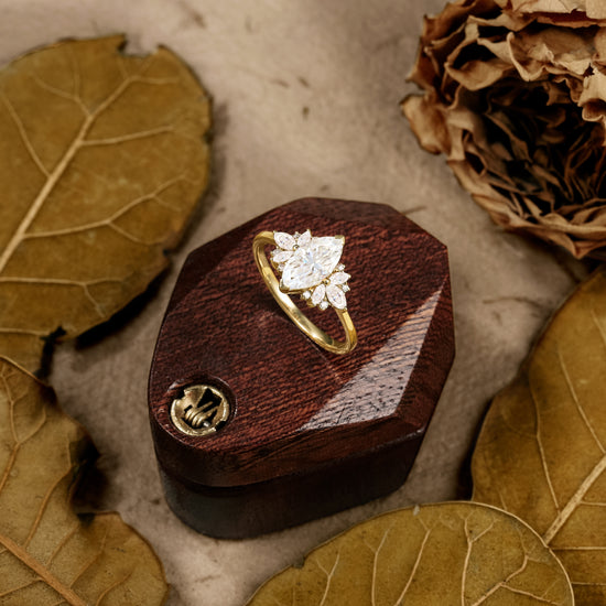 Elegant marquise cut moissanite ring with floral side stones on wooden display