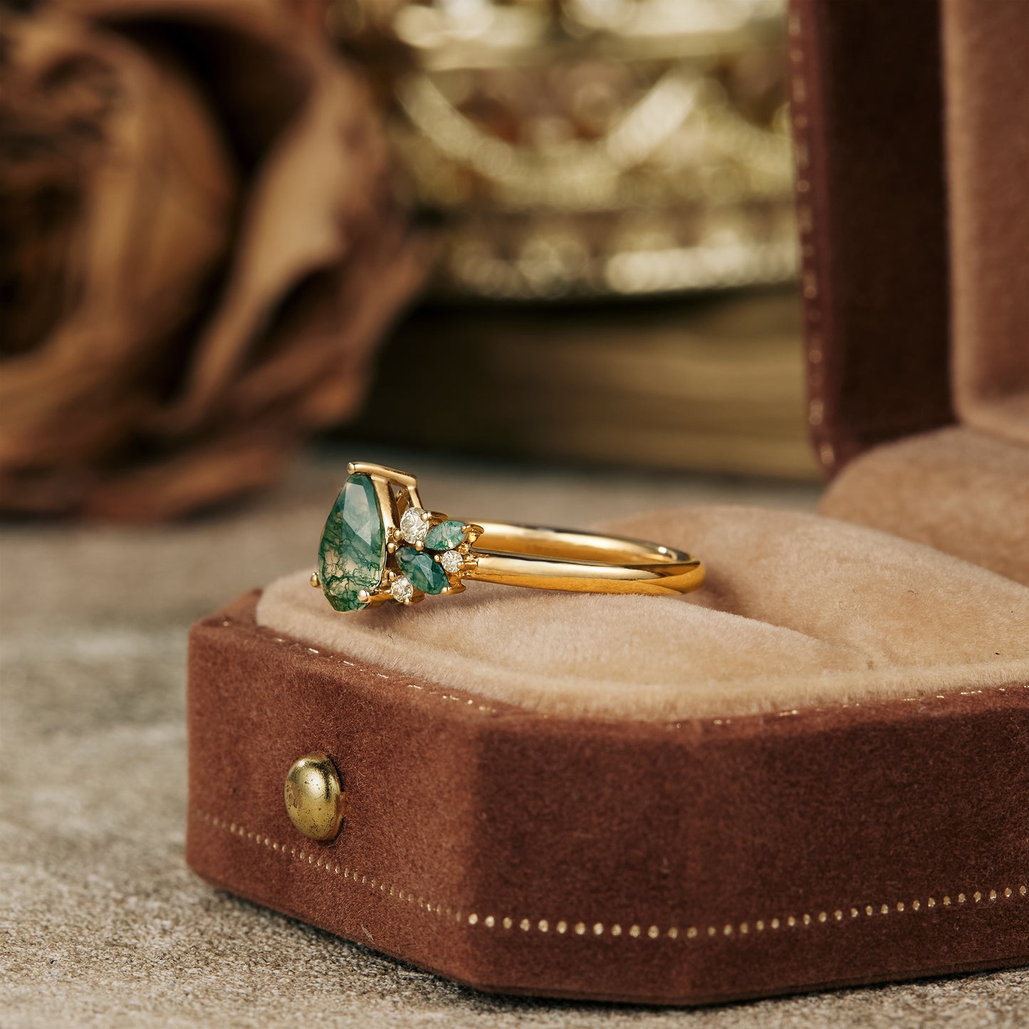 Nature-inspired moss agate ring in gold with pear-cut center and moissanite stones