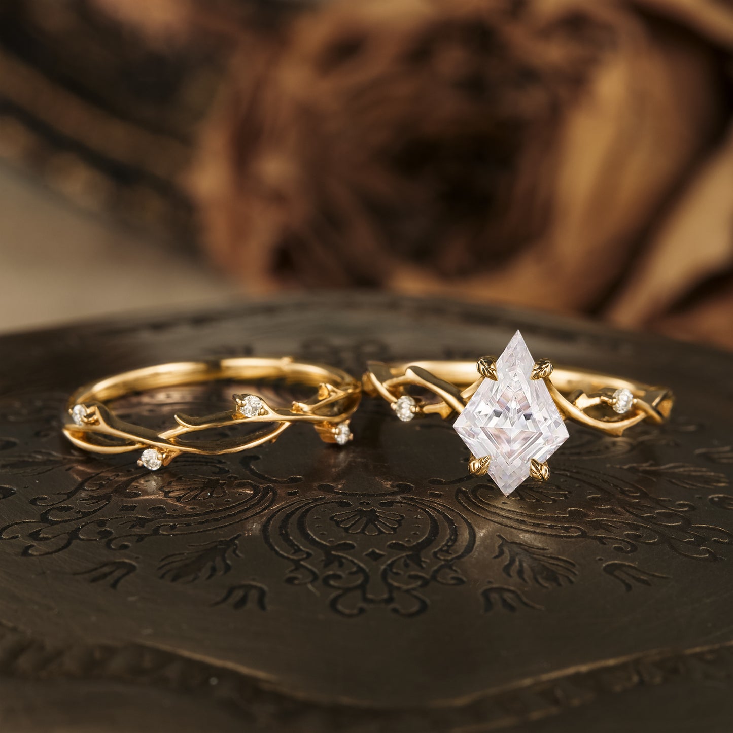 Kite cut moissanite engagement ring with twisted gold band and delicate accent stones.