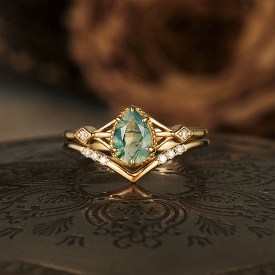 Moss agate pear engagement ring set with moissanite accents on gold band