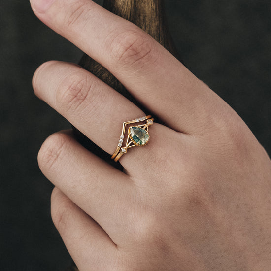 Nature-inspired pear moss agate ring set with moissanite accents on hand